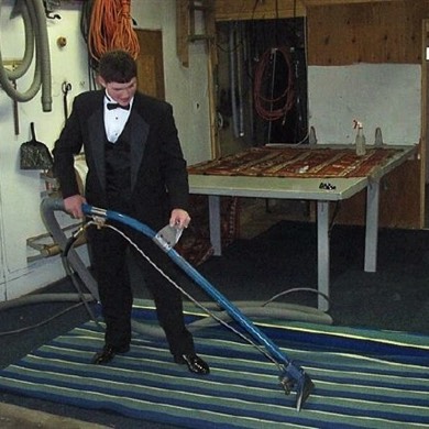 Picture of man cleaning carpet and rug in tux