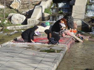Washing rugs in a river